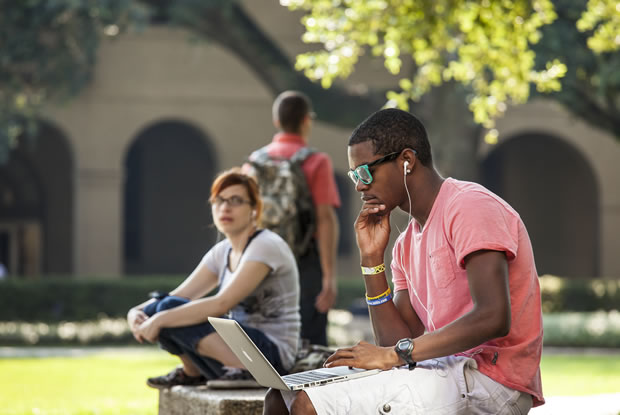 student listening to music in quad